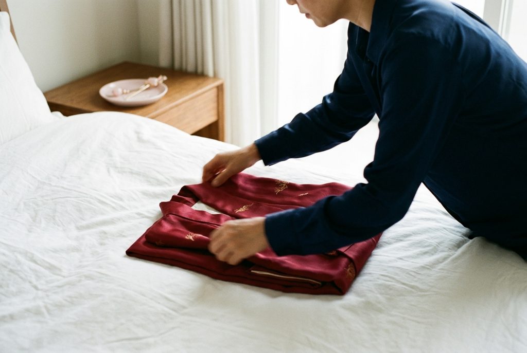 女性がレンタルドレスを急いでたたんでいる様子