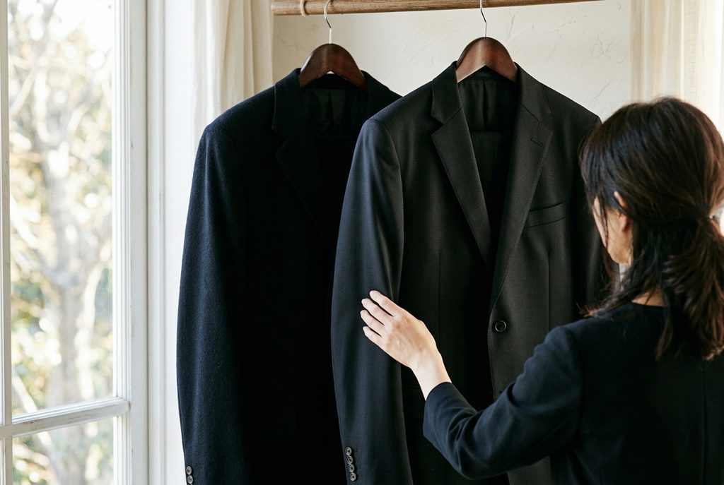 喪服とビジネススーツが並び、素材の質感と黒さの違いがわかる様子
